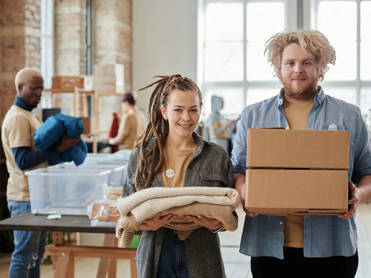 Volunteers carrying boxes and folded donated items