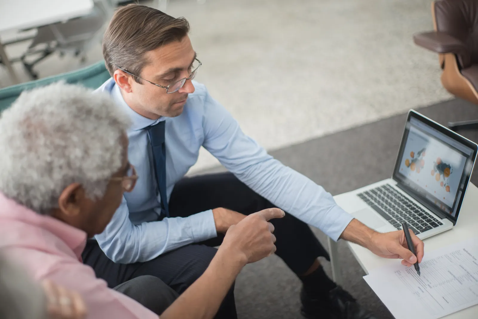 An older adult receiving one-on-one help with a laptop