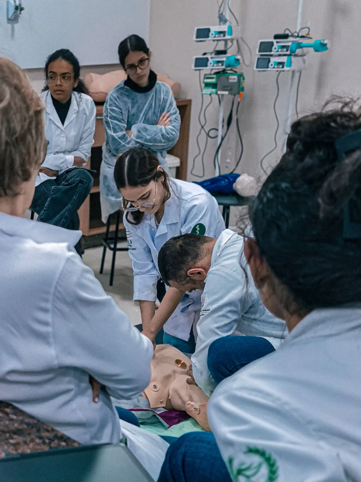 Healthcare students practicing CPR together around a manikin